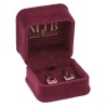Écrin CHA1P-BU ouvert avec une paire de boucles d'oreilles, intérieur velours bordeaux et logo doré MJB