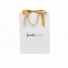 Bolsa de papel blanca para joyería con lazo dorado 180x250x100 mm, vista frontal · BPL180B