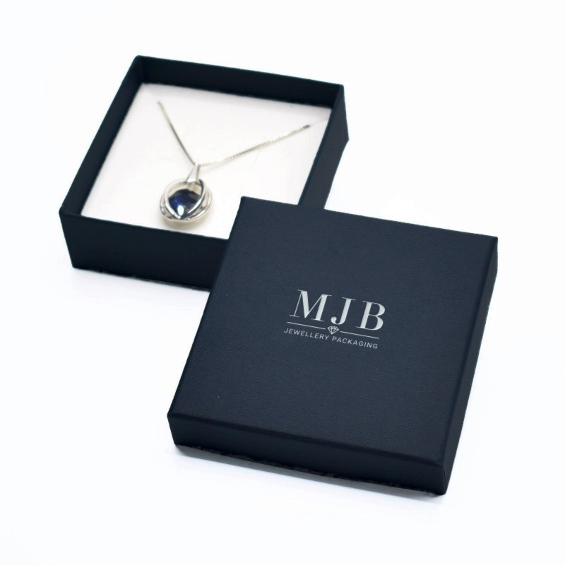 Caja para Colgante 85×85×32 mm - WAS5-A, color azul, abierta con una joya, logotipo plateado MyJewelBoxes