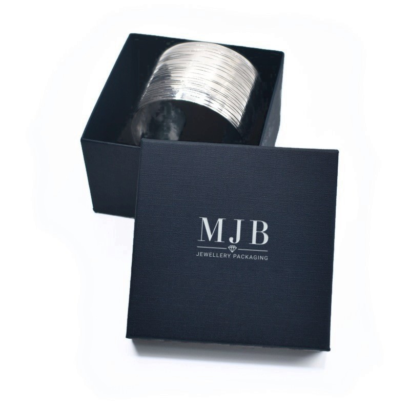 Bangledoosje 90×90×58 mm - WAS8-A, blauw, open met een sieraad, zilverkleurig MyJewelBoxes-logo