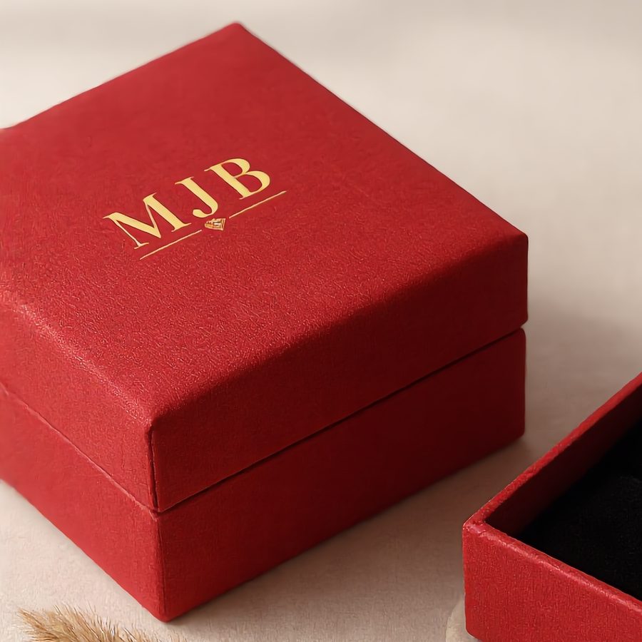 Monograma estampado en caliente en oro sobre la tapa de una caja para joyas